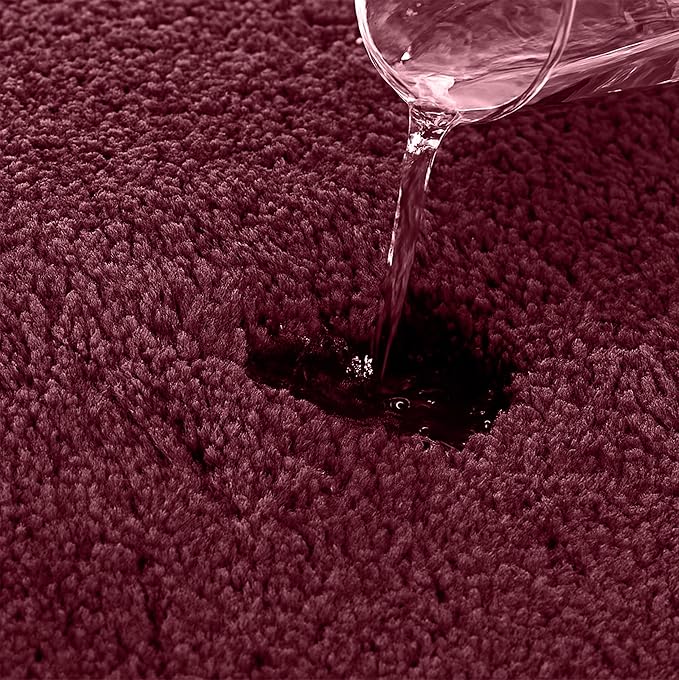 Water being poured on an absorbent maroon bathmat surface