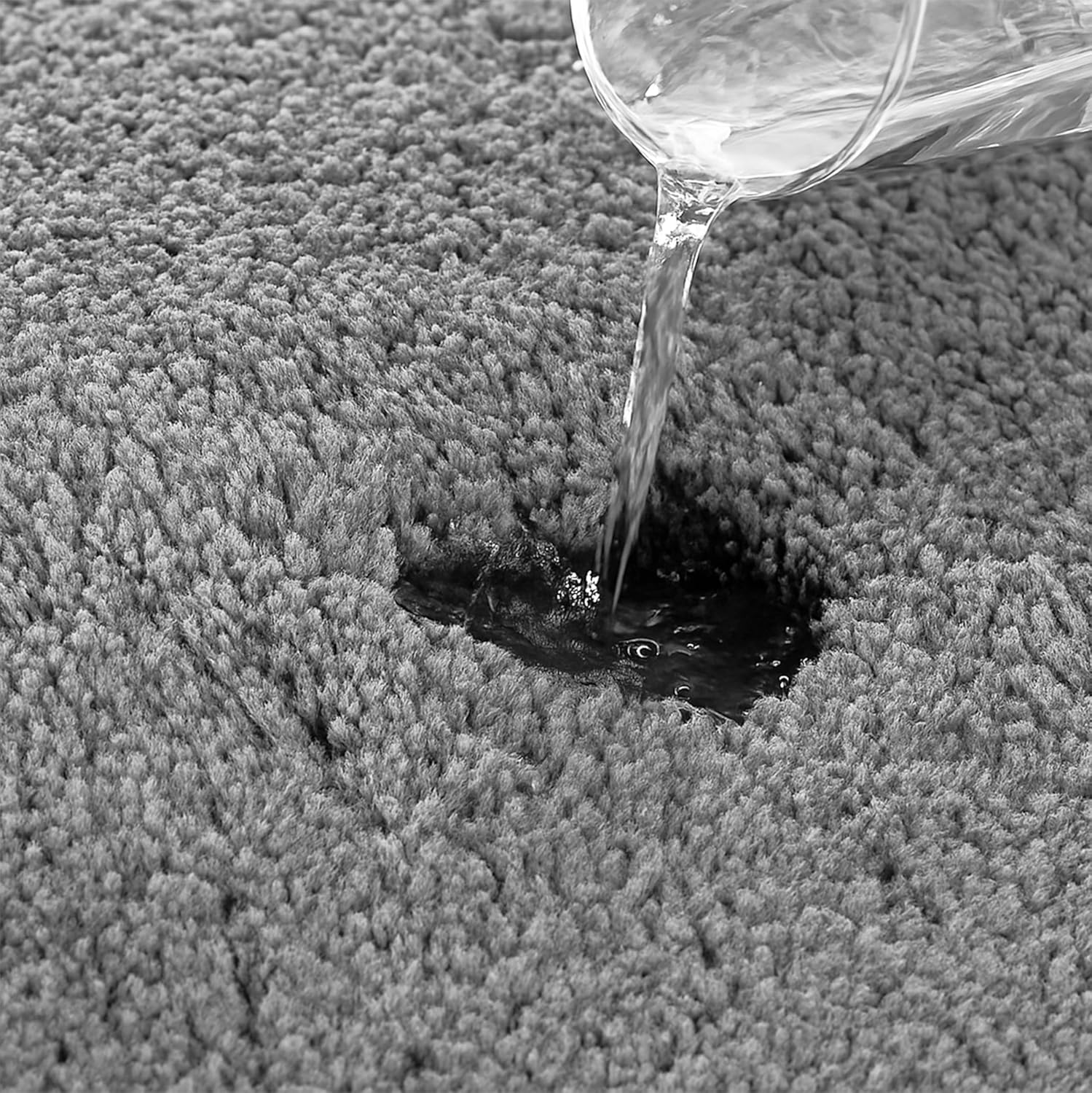 Water being poured on a grey absorbent bathmat to show quick-dry feature