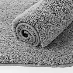 Soft grey bathmat rolled on a matching textured surface, bathroom decor essential