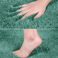Soft green bathmat with hand and foot pressing into plush, absorbent microfiber pile