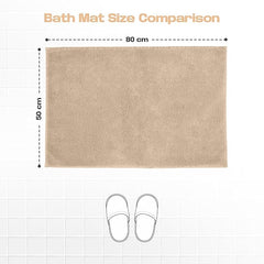 Beige bath mat 50x80 cm on tiled floor with slipper outline for size comparison