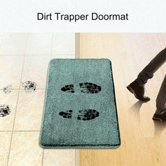 Absorbent dirt trapper doormat capturing muddy footprints at doorway on tile and wood floor