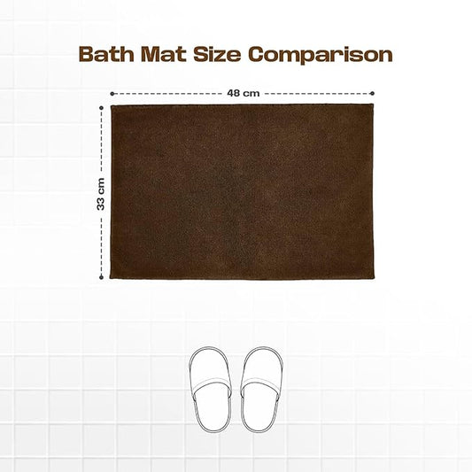 Brown bath mat 48x33 cm shown on tiled floor with slippers for size comparison.