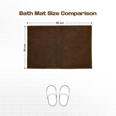 Brown bath mat 48x33 cm shown on tiled floor with slippers for size comparison.