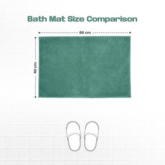Green bath mat measuring 60x40 cm on tiled floor, illustrated with slippers for size comparison
