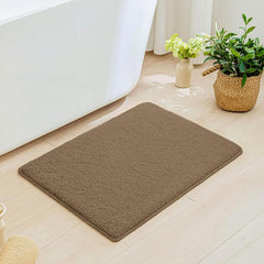 Brown bathmat on bathroom floor beside bathtub, with indoor plants and natural decor